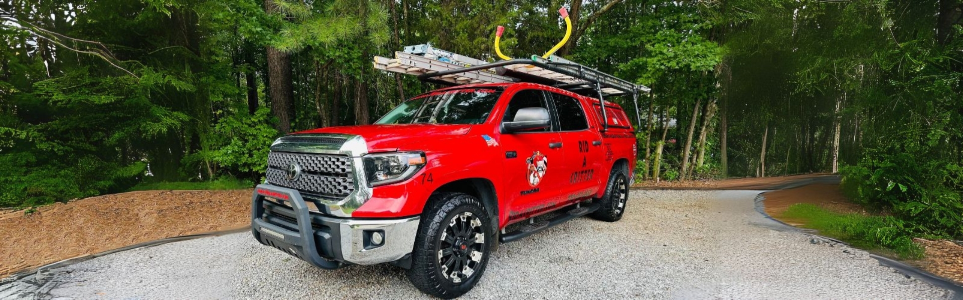 Rid A Critter Red Truck with Ladders on top, ready to get to work. Wildlife Removal - Columbus GA - Rid A Critter